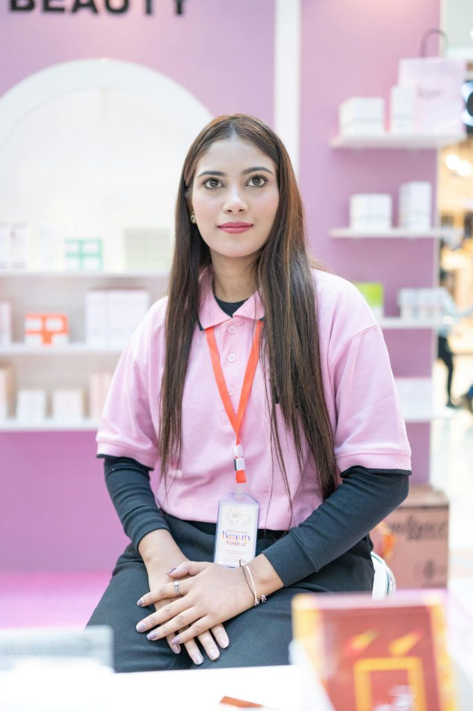 Smiling staff member at a beauty booth in Islamabad. Ideal for business and beauty industry content.