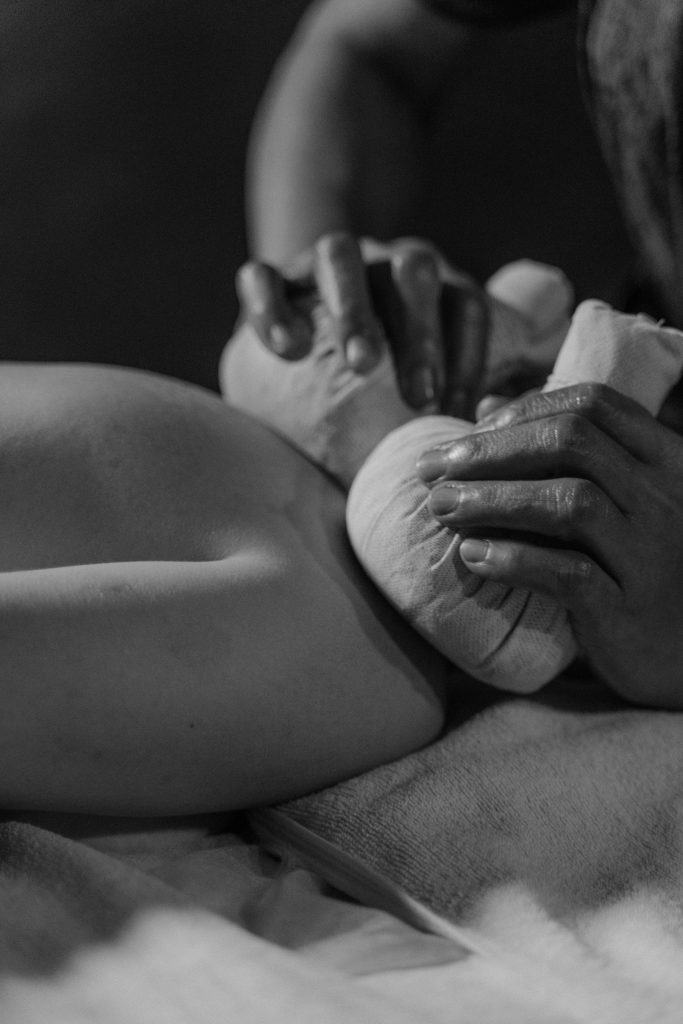 Close-up of a relaxing massage therapy session in black and white.